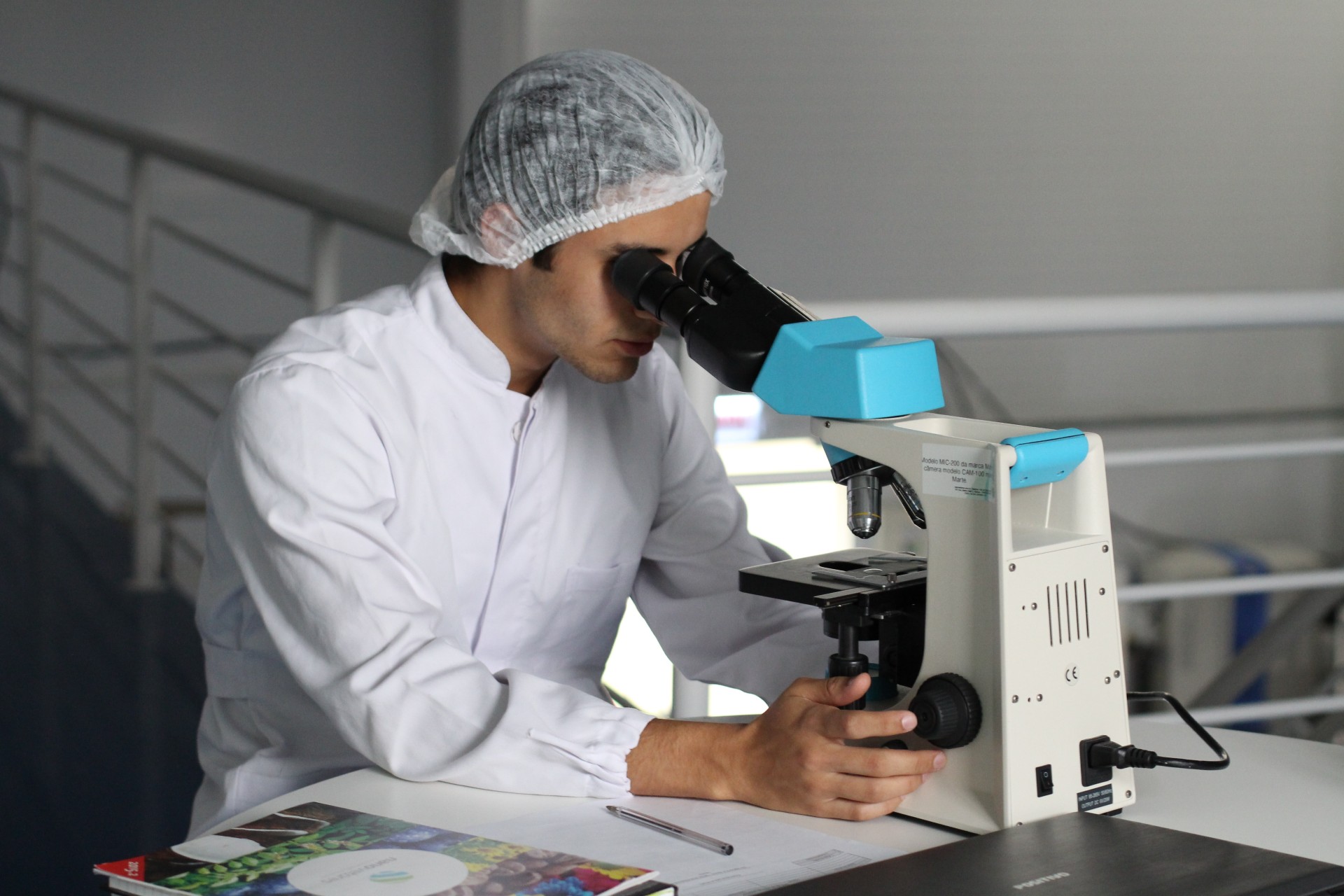 Man looking into microscope in lab.
